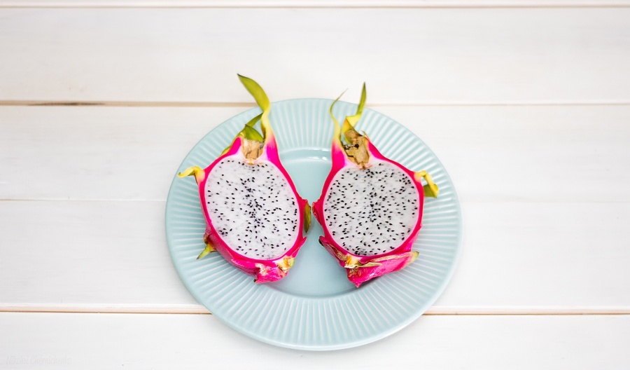 dragon fruit sliced in half on a blue plate