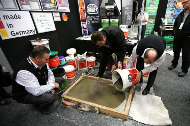 Exhibitors pouring concrete at their booth 