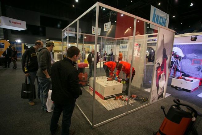 An expo booth with exhibitors showing power tools being used